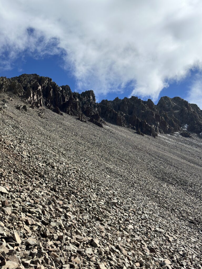 A scree field with rocky peaks