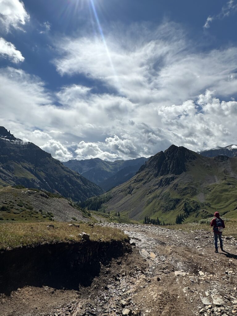 Jon standing and looking at the peaks and valley during the descent from Mount Sneffels