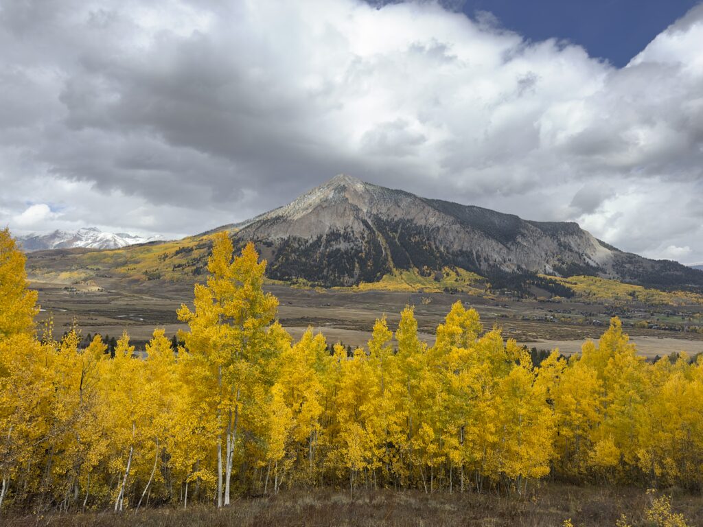 Yellow aspen trees framing a mountain scene in Crested Butte in the autumn